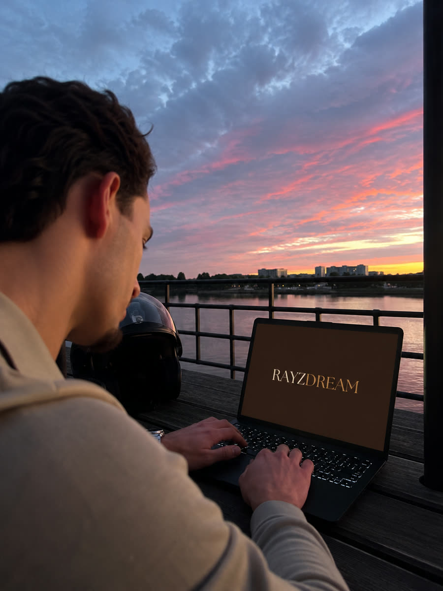 Rayan Ahmad werkt aan een RAYZDREAM website bij zonsondergang aan de Schelde in Antwerpen